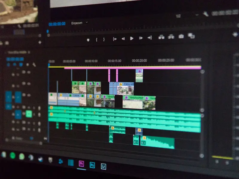 A video editing timeline with clips and audio tracks on a computer monitor