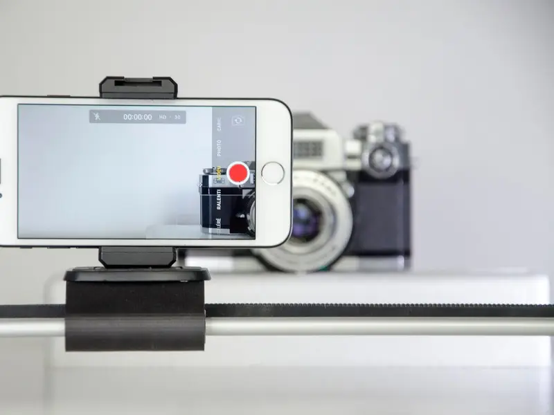 A smartphone on a rig recording a close-up video of a camera, as for a product ad