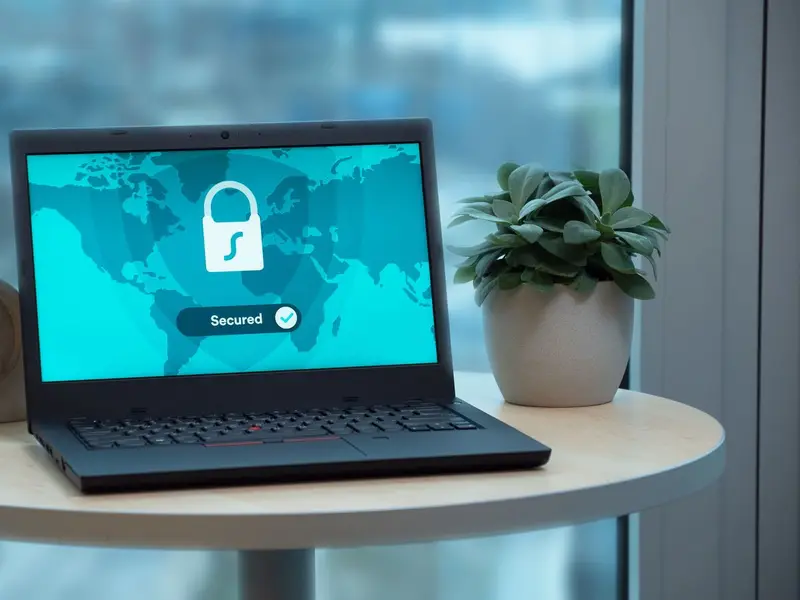 A laptop on a small table showing a padlock icon and the word secured