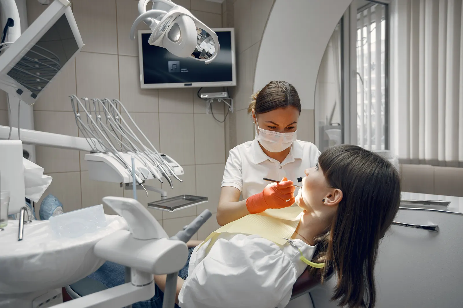 A dentist examining a patient in the chair of a modern dental surgery.