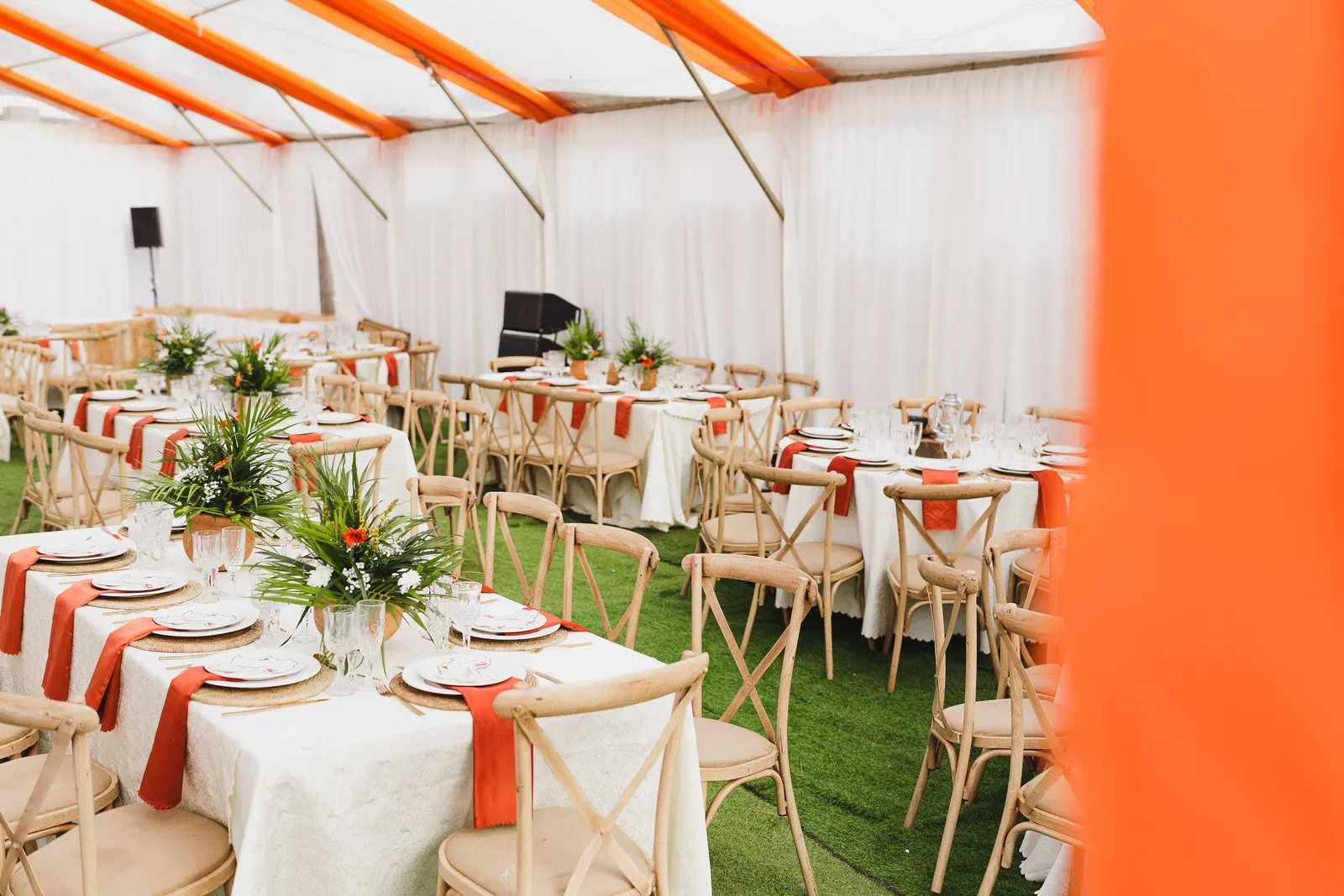 Long tables set with flowers and place settings inside a marquee before the guests arrive.