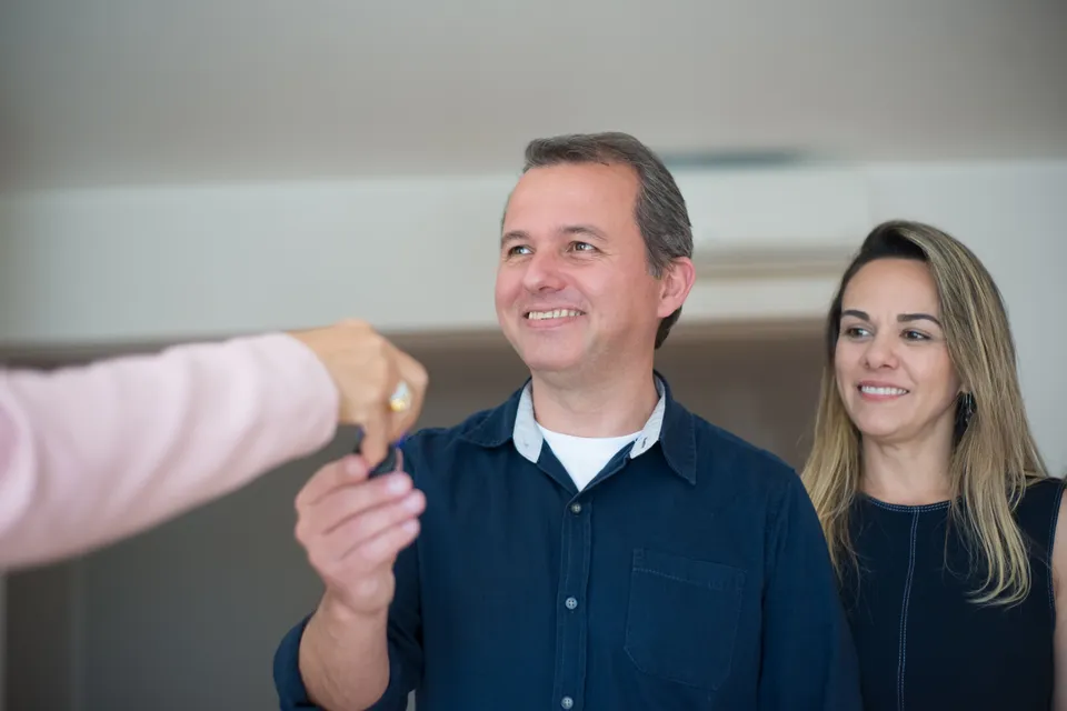 A couple being handed the keys to their new home.