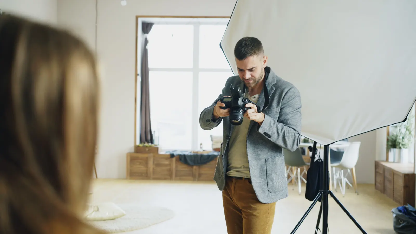 A photographer checking the camera while setting up a shot in a studio.