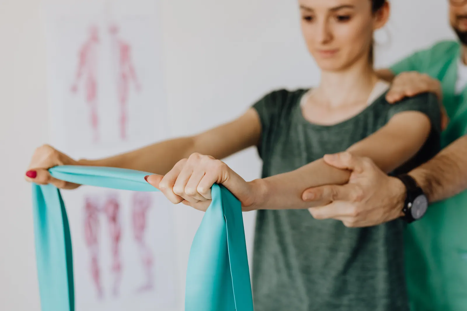 A physiotherapist guiding a patient through an arm exercise with an elastic band.