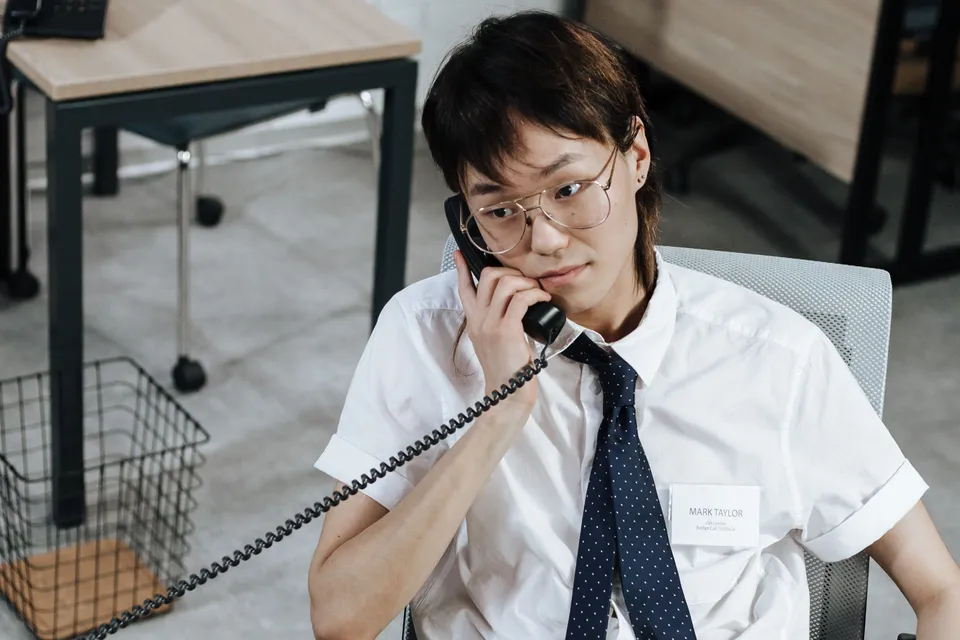 A recruiter on the desk phone, listening closely during a call.